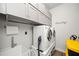 Modern laundry room with front load washer, dryer and storage cabinets at 322 Woodridge Pass, Canton, GA 30114