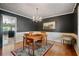 Elegant dining room with a chandelier, hardwood floors, dark accent walls and a large wooden table at 400 Simpson Ne Rd, White, GA 30184