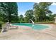 Inviting backyard swimming pool featuring a slide and a diving board, surrounded by lush greenery at 400 Simpson Ne Rd, White, GA 30184