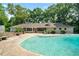 Beautiful pool with surrounding patio for outdoor gatherings, with an attached screened porch and lush landscaping at 400 Simpson Ne Rd, White, GA 30184