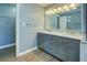 Bathroom featuring double sinks, granite counters, and a walk-in closet at 1103 Wallington Nw Ct, Conyers, GA 30012