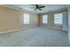 Large bedroom with neutral walls, plush carpeting, and abundant natural light from three windows at 1103 Wallington Nw Ct, Conyers, GA 30012
