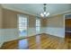 Bright living room with hardwood floors, wainscoting, and large windows bringing in natural light at 1103 Wallington Nw Ct, Conyers, GA 30012