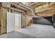 Unfinished basement with insulation, concrete floor, and doorway to potential storage space at 187 Gilberts Way, Temple, GA 30179