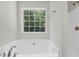 Corner bathtub beneath a window providing natural light and fresh air at 187 Gilberts Way, Temple, GA 30179