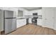 Bright kitchen featuring stainless steel appliances, white cabinets, and a wood-style floor at 187 Gilberts Way, Temple, GA 30179