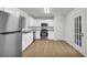 Modern kitchen with stainless steel appliances, white cabinets, and a stylish wood floor at 187 Gilberts Way, Temple, GA 30179