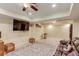 Open basement area with large television, leather couch, decorative rug, and tile flooring at 262 Sandhurst Ct, Suwanee, GA 30024