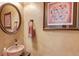 Stylish half bath with a stone vessel sink, decorative mirror, and elegant wall art at 262 Sandhurst Ct, Suwanee, GA 30024
