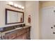Well-lit bathroom with a dark wood vanity, granite countertop, and a large decorative mirror at 262 Sandhurst Ct, Suwanee, GA 30024