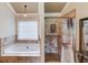 Bright bathroom featuring a soaking tub, tiled shower, and neutral color palette at 262 Sandhurst Ct, Suwanee, GA 30024