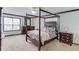 Spacious bedroom with a four-poster bed, carpet flooring, and ample natural light from two windows at 262 Sandhurst Ct, Suwanee, GA 30024