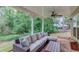 Inviting covered patio featuring a comfortable sectional sofa and serene wooded views, perfect for relaxation and outdoor living at 262 Sandhurst Ct, Suwanee, GA 30024