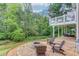 Expansive brick patio with fire pit and wooded surround perfect for outdoor entertaining at 262 Sandhurst Ct, Suwanee, GA 30024