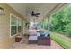 Covered outdoor patio with cushioned seating and views of the green backyard at 262 Sandhurst Ct, Suwanee, GA 30024
