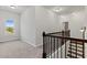 Bright hallway featuring a window view and a staircase with dark wood banister at 2887 Regal Park Ct, Duluth, GA 30096