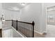 Upstairs hallway featuring dark wood railings, natural light, and access to multiple rooms at 2887 Regal Park Ct, Duluth, GA 30096