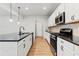 Modern kitchen with white cabinets, stainless steel appliances, and a black granite island at 2887 Regal Park Ct, Duluth, GA 30096