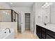 Well-lit main bathroom with a walk-in shower, soaking tub, and double vanity with a dark finish at 2887 Regal Park Ct, Duluth, GA 30096
