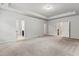 Bright and airy main bedroom featuring tray ceilings and multiple doorways, with neutral color palette at 2887 Regal Park Ct, Duluth, GA 30096