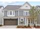 Exterior of two-story house boasts a front-facing garage, neat landscaping and charming curb appeal at 4002 Potter Way, Woodstock, GA 30188