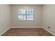 Clean, empty bedroom with vinyl floors, a large window, and neutral paint at 2045 Scarbrough Dr, Stone Mountain, GA 30088