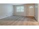 Inviting living room with plush carpeting, a large window, and a bright white door at 2045 Scarbrough Dr, Stone Mountain, GA 30088