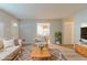 Bright living room with modern furniture, neutral color palette, and view into kitchen at 2045 Scarbrough Dr, Stone Mountain, GA 30088