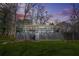 Backyard view of the house at dusk featuring a deck and grassy lawn at 2826 Ben Hill Rd, Atlanta, GA 30344