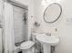Modern bathroom featuring tiled shower with a decorative round mirror above the sink at 2826 Ben Hill Rd, Atlanta, GA 30344