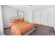 This bedroom has carpet, neutral walls, and a comfortable bed with an orange comforter at 2826 Ben Hill Rd, Atlanta, GA 30344