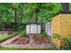 Well-maintained garden area featuring raised beds, a storage shed, and mature trees at 3580 Raymond Dr, Atlanta, GA 30340