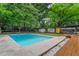 Beautiful swimming pool surrounded by lush landscaping, a patio area, and a storage shed at 3580 Raymond Dr, Atlanta, GA 30340
