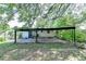 View of the backyard featuring a covered patio, chain-link fence, and mature trees for a tranquil outdoor setting at 3991 Adamsville Sw Dr, Atlanta, GA 30331