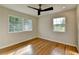 Bright bedroom featuring hardwood floors, updated ceiling fan, and natural light from updated windows at 3991 Adamsville Sw Dr, Atlanta, GA 30331