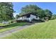 Charming home with a paved driveway, lush green lawn, and mature trees at 3991 Adamsville Sw Dr, Atlanta, GA 30331