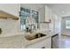 Close up of the kitchen sink, white cabinets, granite countertops, and stainless steel appliances at 3991 Adamsville Sw Dr, Atlanta, GA 30331