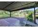 Covered outdoor patio area surrounded by a chain-link fence, leading to the backyard and garden at 3991 Adamsville Sw Dr, Atlanta, GA 30331