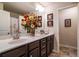 Bathroom with double sink vanity, dark wood cabinets, quartz countertops, and decorative flowers at 4305 Hunters Walk Way, Cumming, GA 30028