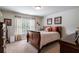 Cozy bedroom featuring a queen bed, side tables, light walls, dark wood furniture, and natural light at 4305 Hunters Walk Way, Cumming, GA 30028