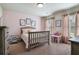 This charming bedroom is staged with pink color accents, neutral walls, and a -sized seating area at 4305 Hunters Walk Way, Cumming, GA 30028