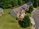 Aerial shot of a brick home with an attached two-car garage, green lawn, and mature trees at 4305 Hunters Walk Way, Cumming, GA 30028