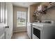 Well-lit laundry room with modern washer and dryer, plus storage shelves for convenience at 4305 Hunters Walk Way, Cumming, GA 30028