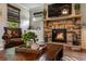 Cozy living room with stone fireplace, wooden coffee table, and leather armchair for relaxing and entertaining at 4305 Hunters Walk Way, Cumming, GA 30028