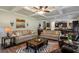 Open-concept living room flows into kitchen featuring coffered ceiling, stone fireplace, and lots of seating at 4305 Hunters Walk Way, Cumming, GA 30028