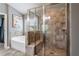 This tiled shower features a glass enclosure with a bench, showerhead and corner shelf, and an adjacent garden tub at 4305 Hunters Walk Way, Cumming, GA 30028