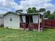 Home's cozy back porch with a roof, railing, and curtains for privacy at 60 King Blvd, Mcdonough, GA 30253