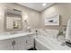 Clean bathroom with marble vanity, framed mirror, a deep tub, and warm, inviting ambiance at 1540 Kinglet Ln, Marietta, GA 30062