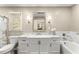 Bright bathroom featuring a vanity with marble counters, a framed mirror and tub with tiled walls at 1540 Kinglet Ln, Marietta, GA 30062