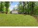 Lush backyard with a spacious lawn, mature trees, and a rustic wooden fence, offering privacy and serenity at 171 North Trce, Alpharetta, GA 30009